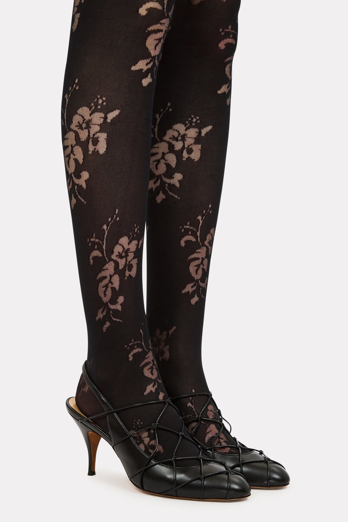 ⁣⁢Collants à motif bouquet tonal noir, gros plan sur la jambe avec des talons | Ulla Johnson⁤⁣