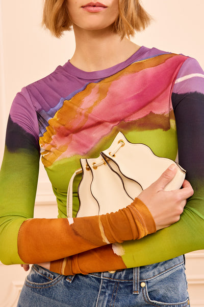 ⁣⁢Mannequin tenant le sac bandoulière Adria Wave de luxe en cuir Cowrie contre son corps - Look stylisé | Ulla Johnson⁤⁣