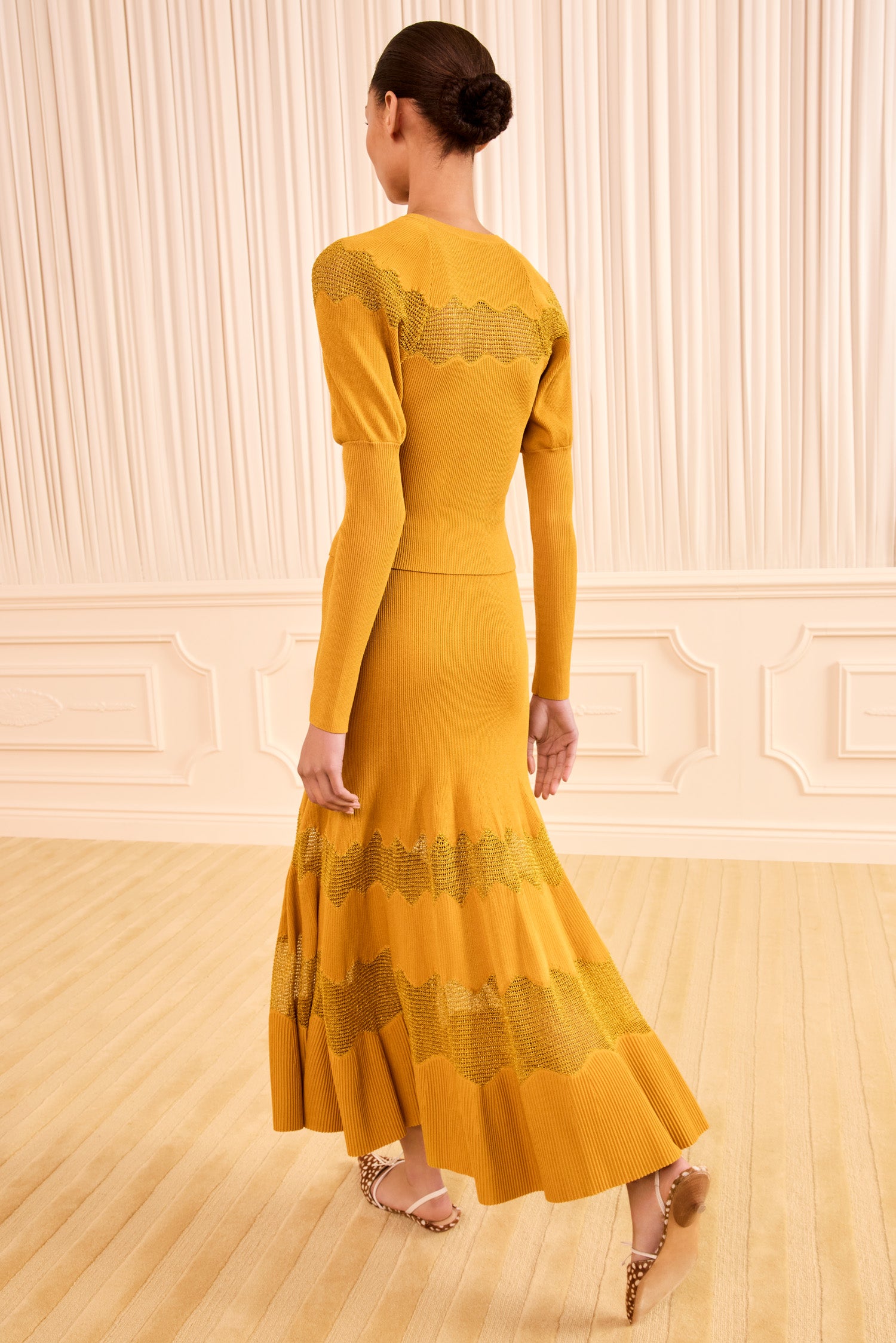 Ulla Johnson Topaz Gold Lurex Midi Knit Skirt - Back View Showing Fluted Hem On Model | Ulla Johnson