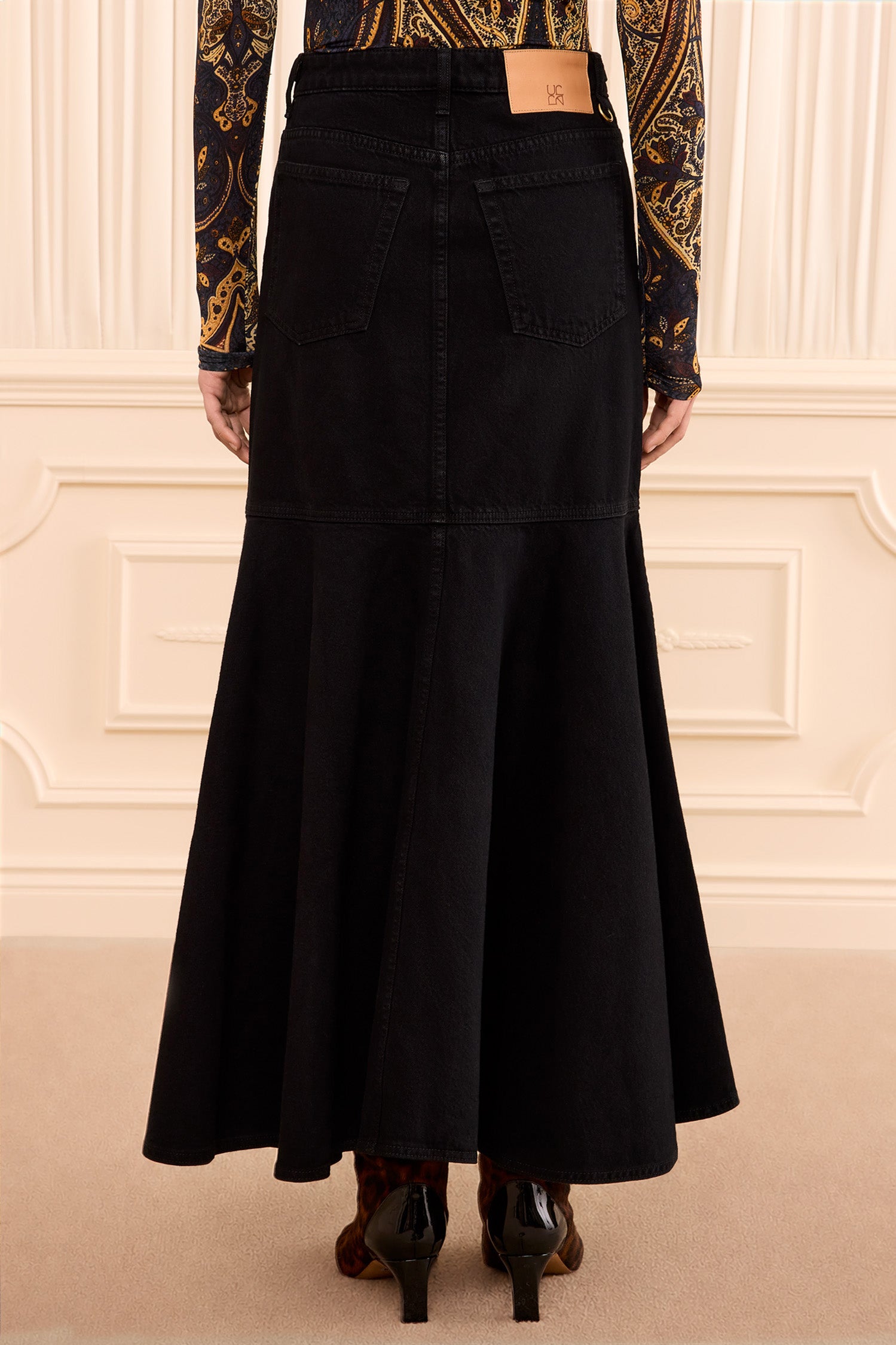 Ulla Johnson Noir Black Premium Denim Midi Skirt - On Model Back View with Logo Patch | Ulla Johnson